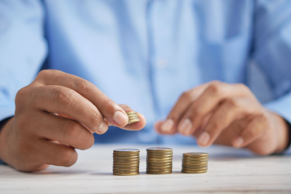 Persona apilando monedas representando inversión en CETES